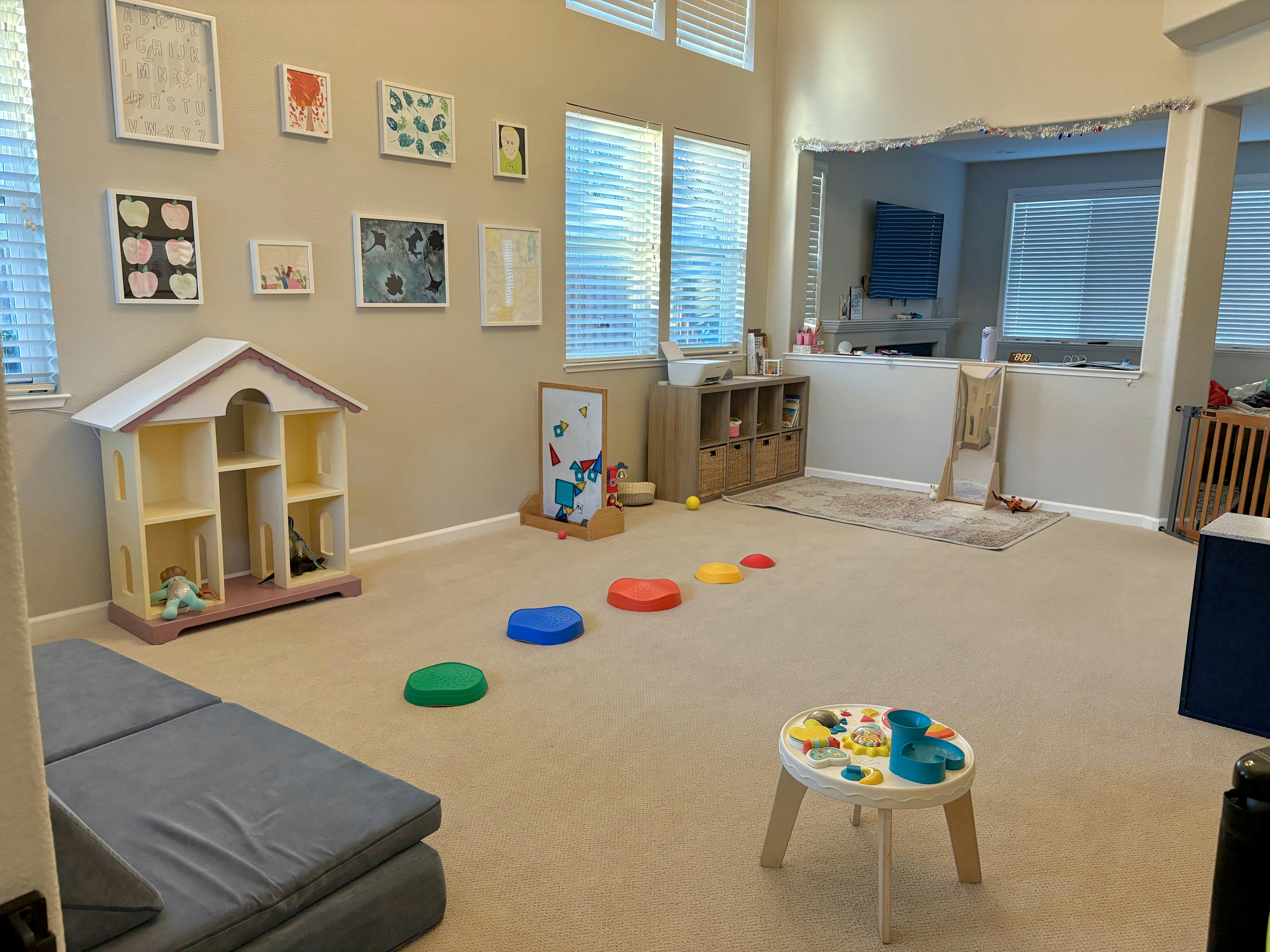Children's playroom with dollhouse, floor cushions, play table, and stepping stones