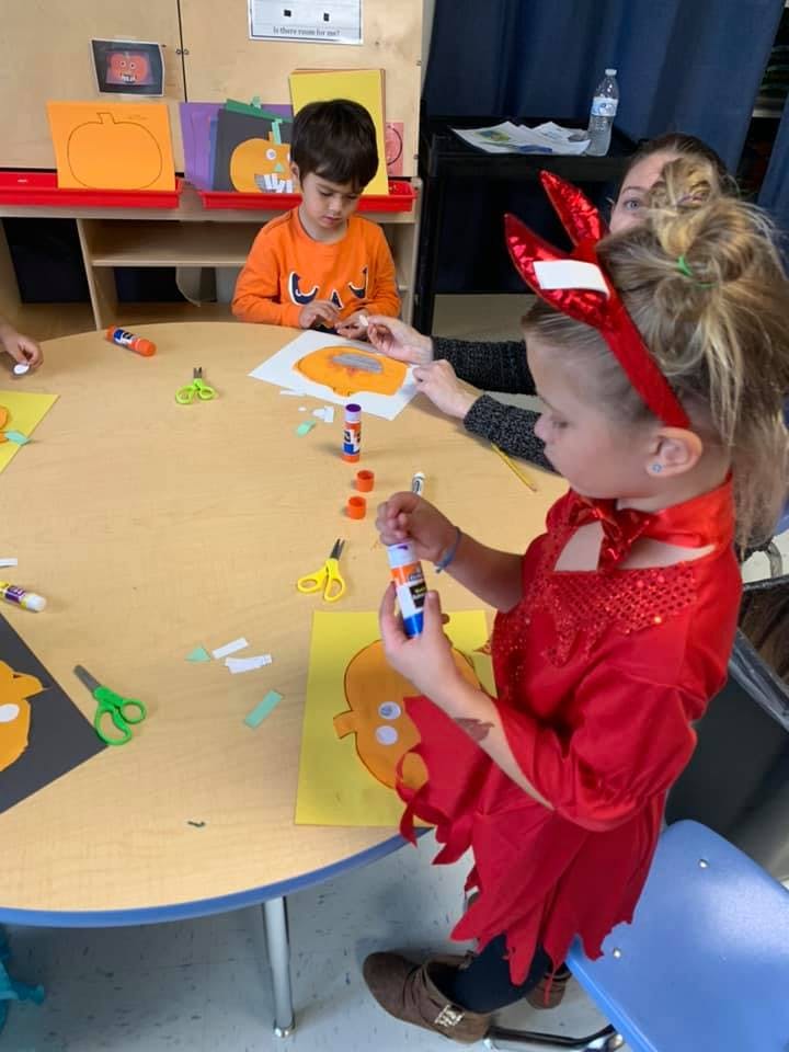 Children and an adult doing crafts at a table