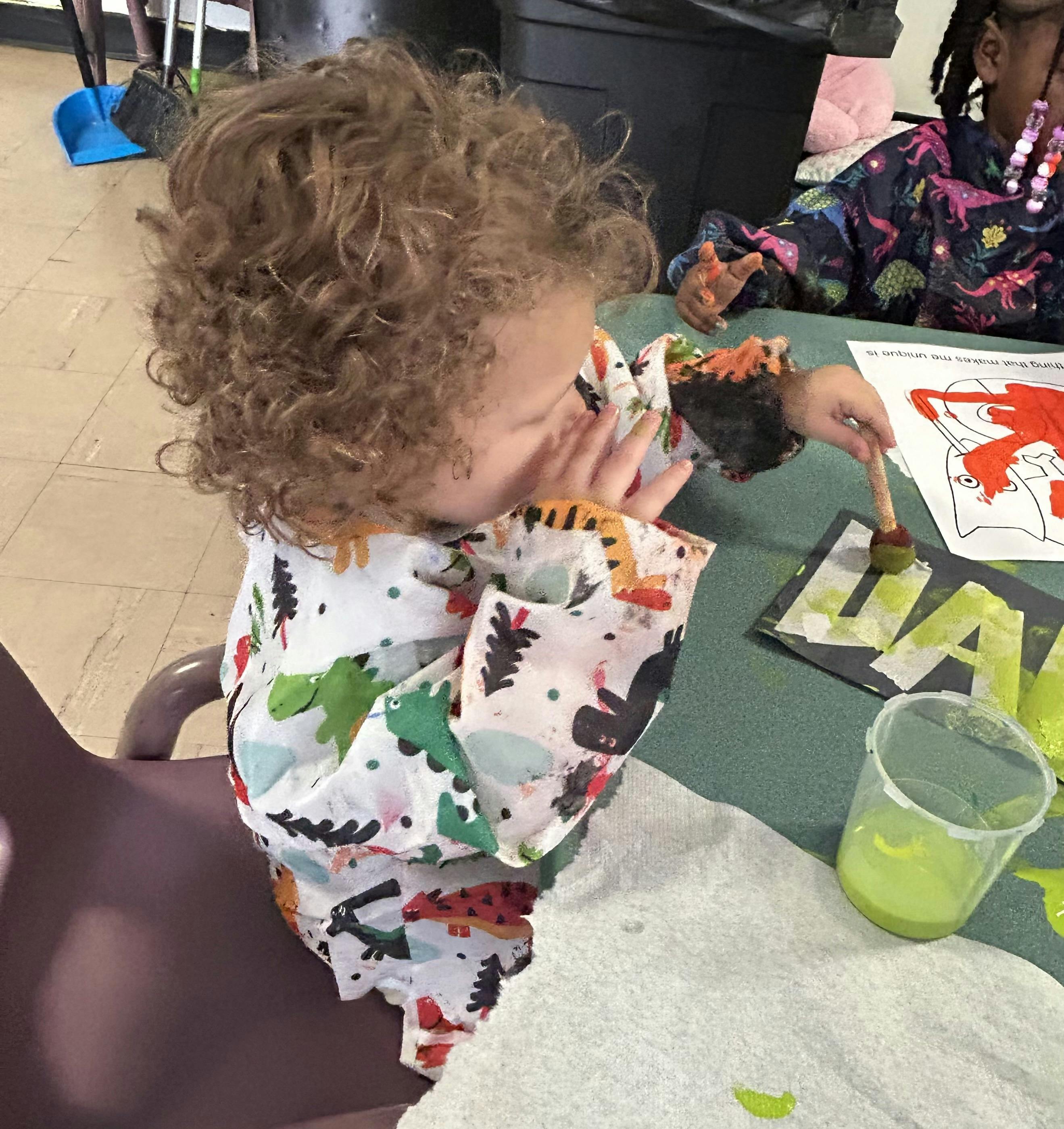 Child painting letters on a table