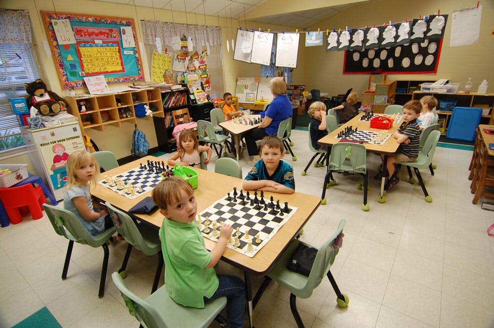 Children playing chess in a classroom