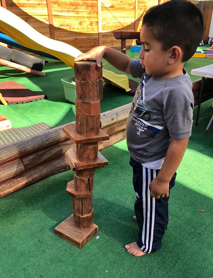 Child playing with a wooden block tower