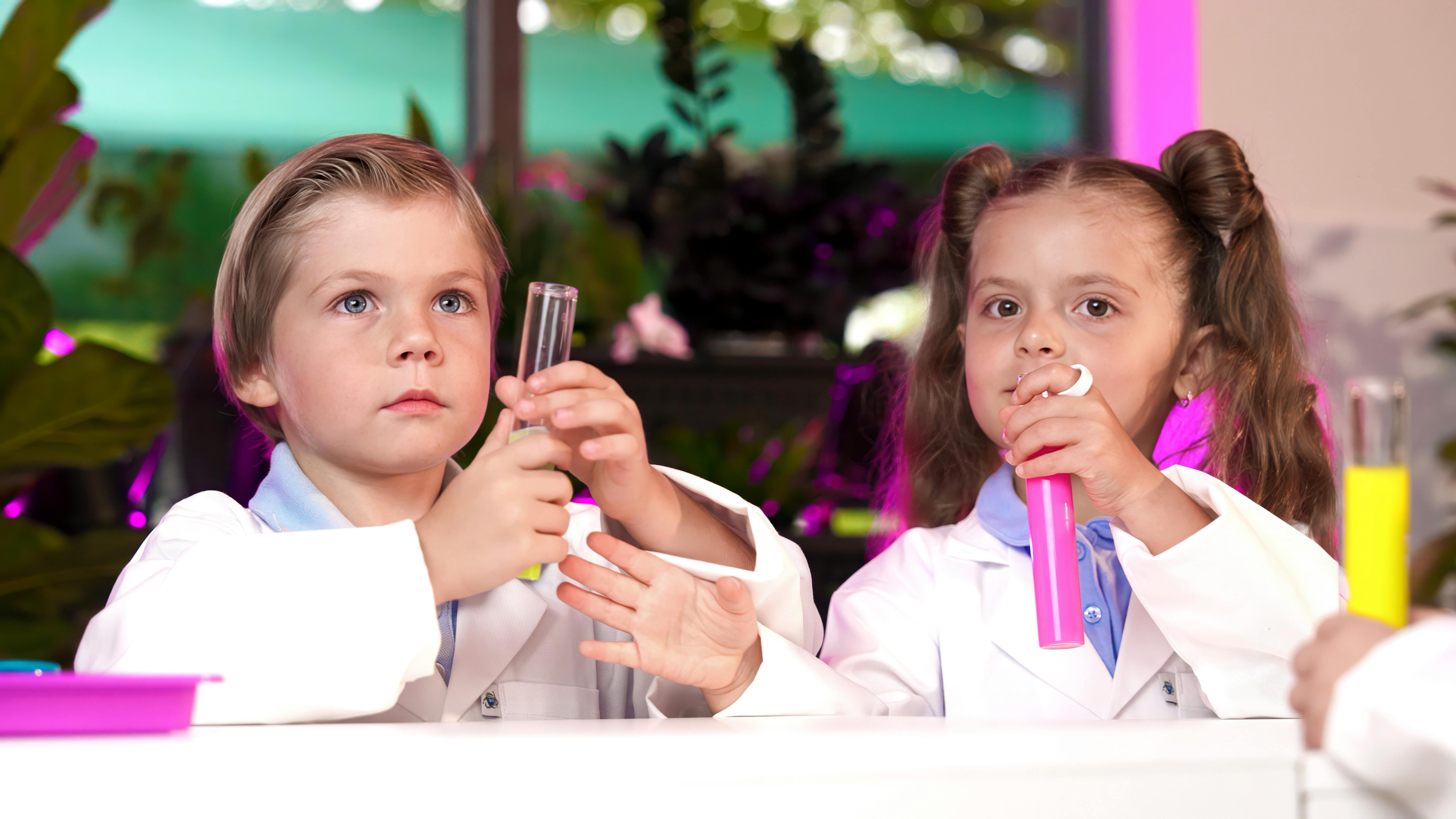 Two children in lab coats holding test tubes