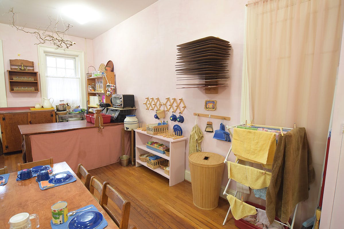 Classroom with tables, shelves, and a drying rack