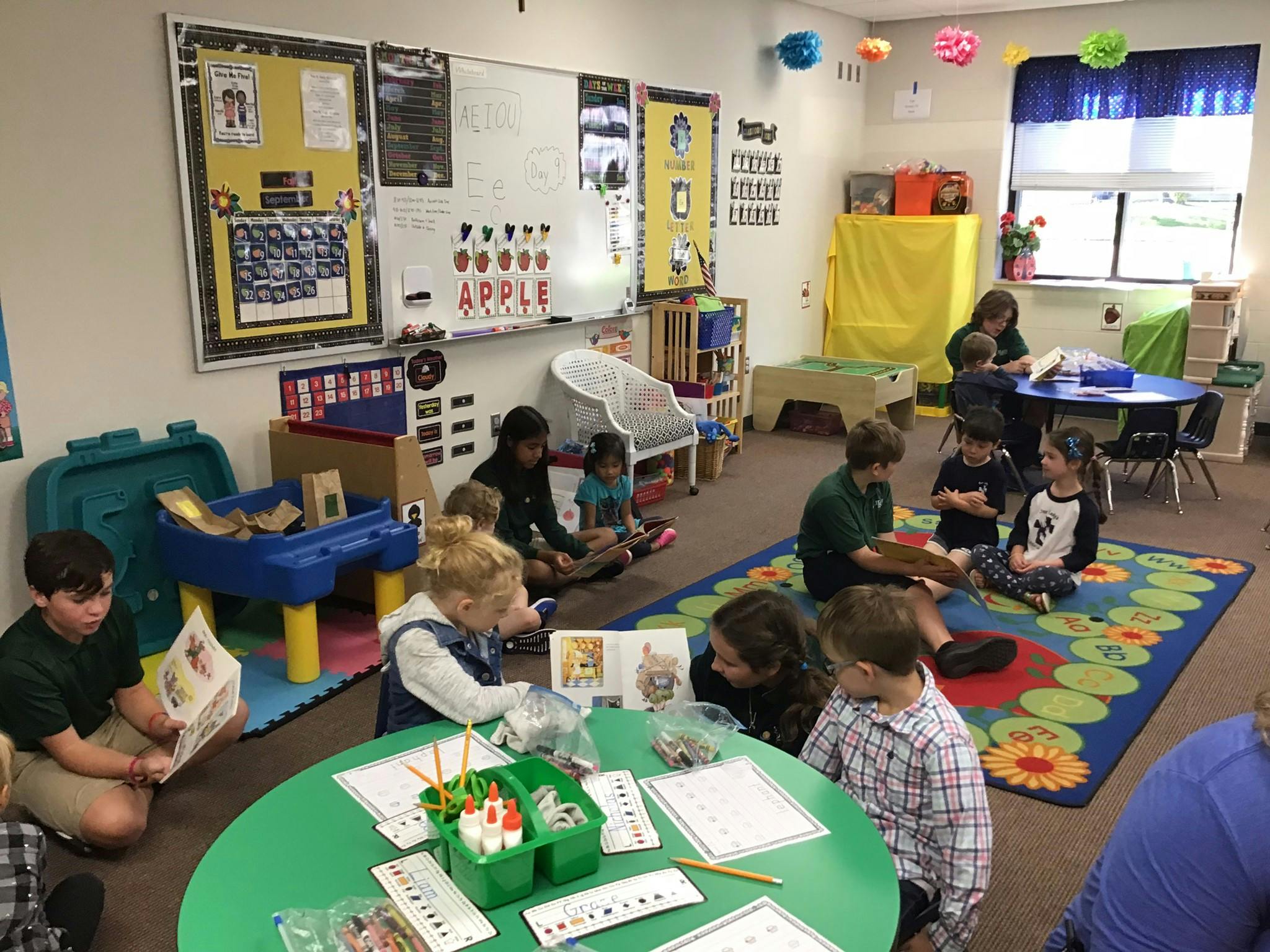 Children and adults reading and working in a classroom