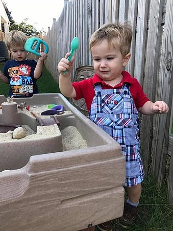 Two children playing in a sandbox