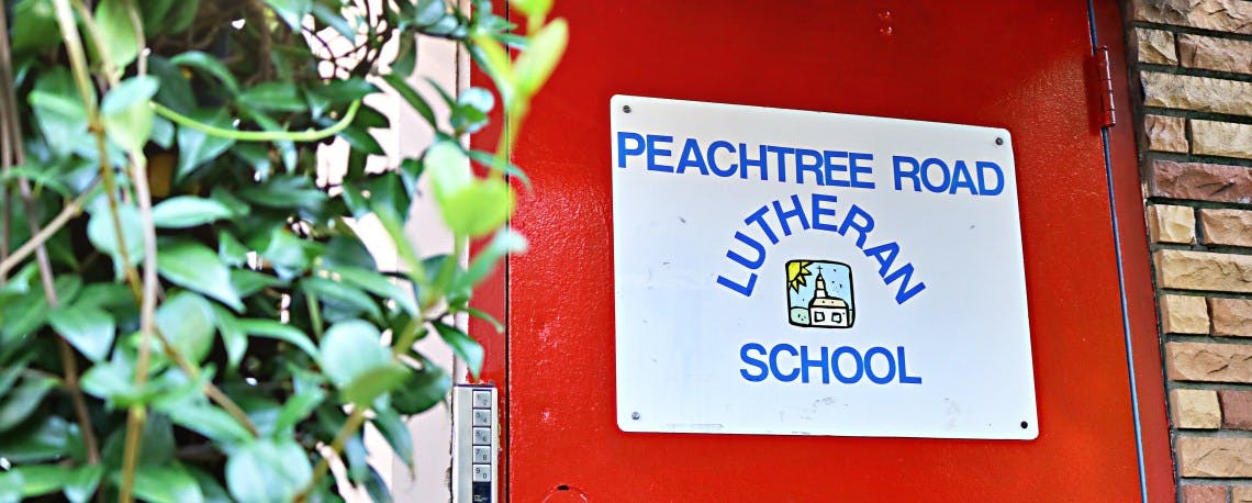 Sign for Peachtree Road Lutheran School on a red door