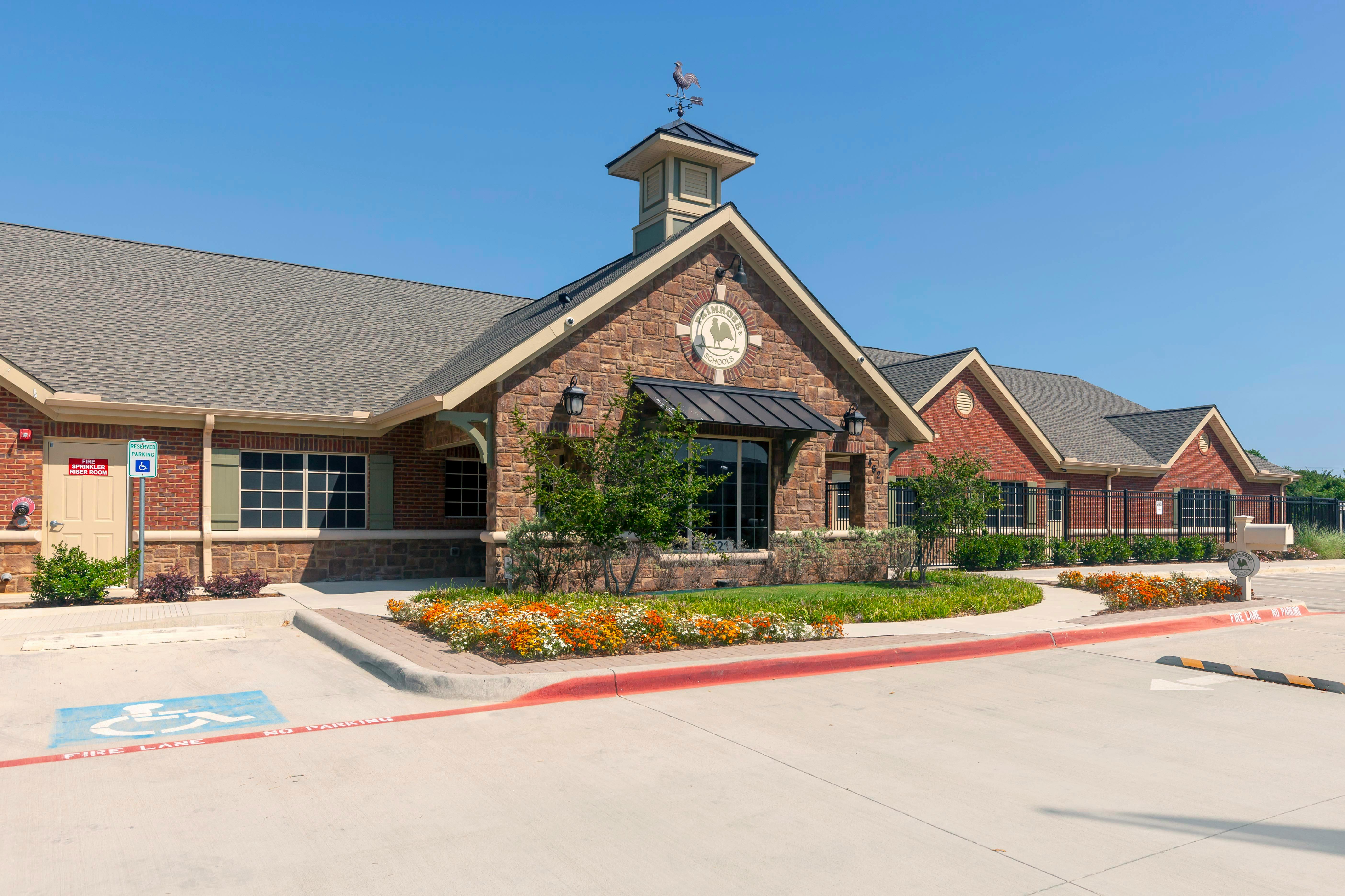 Primrose Schools building exterior with stone and brick facade, steeple, and landscaping