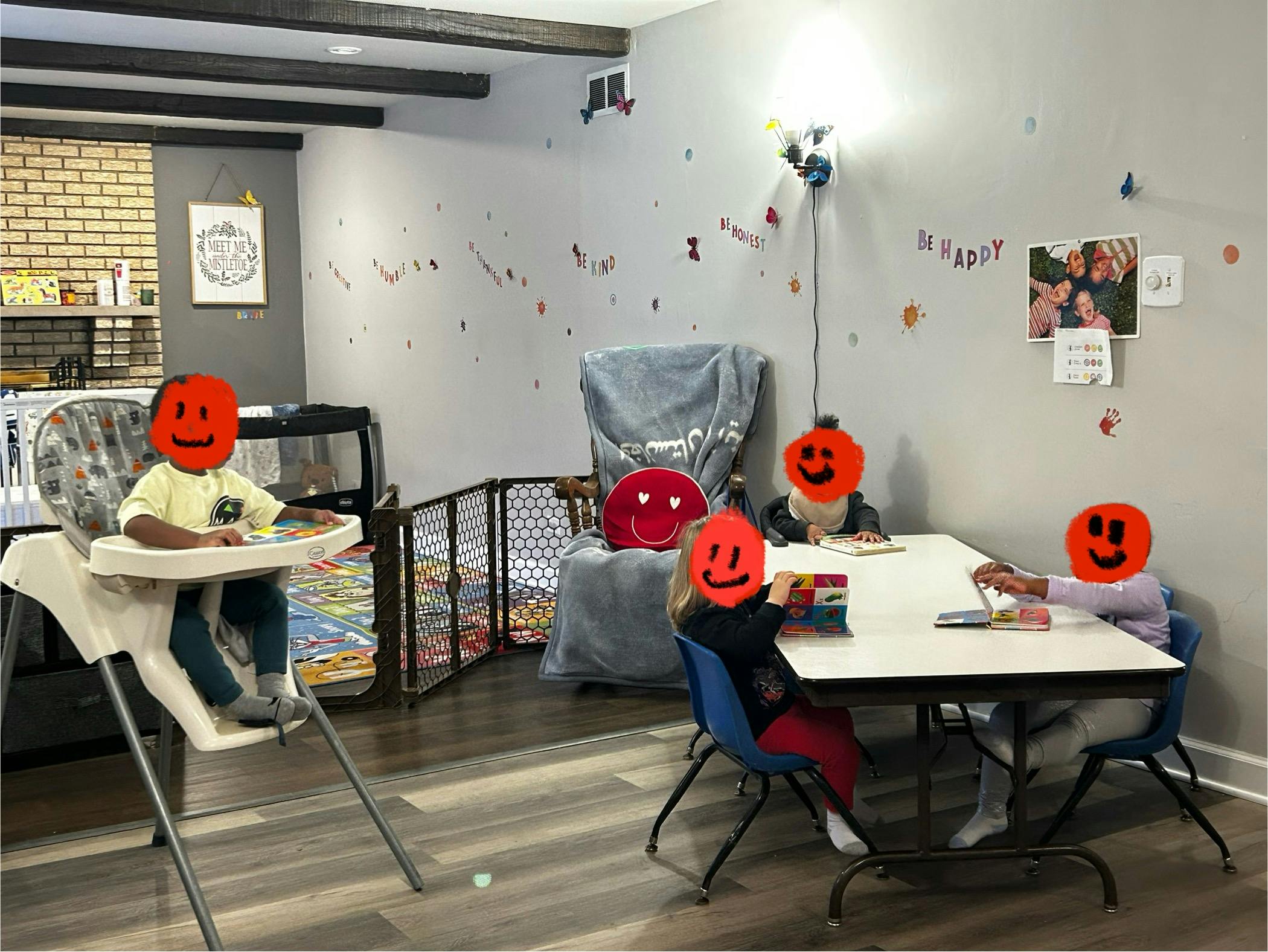 Four children in a room, one in a high chair, three at a table