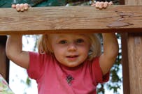 Child looking over a wooden railing