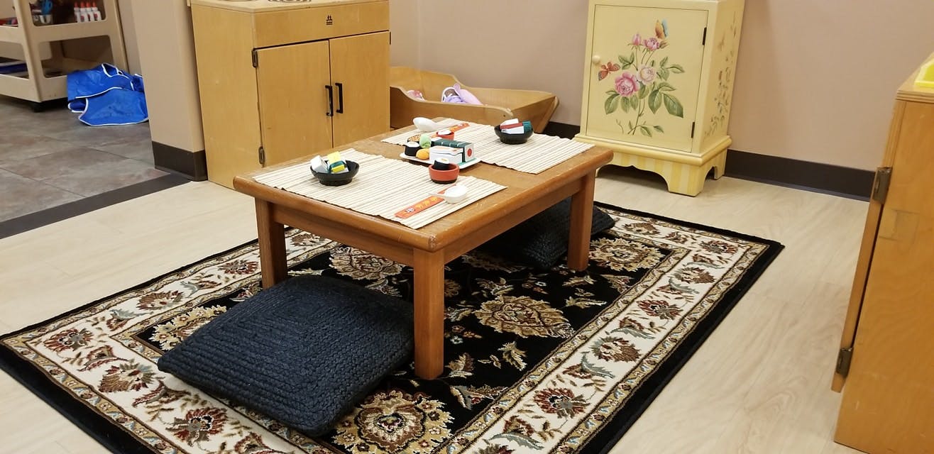 Low wooden table with place settings on a patterned rug