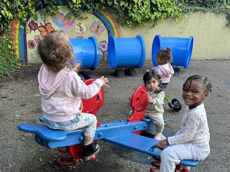 Several children playing on a seesaw at a playground