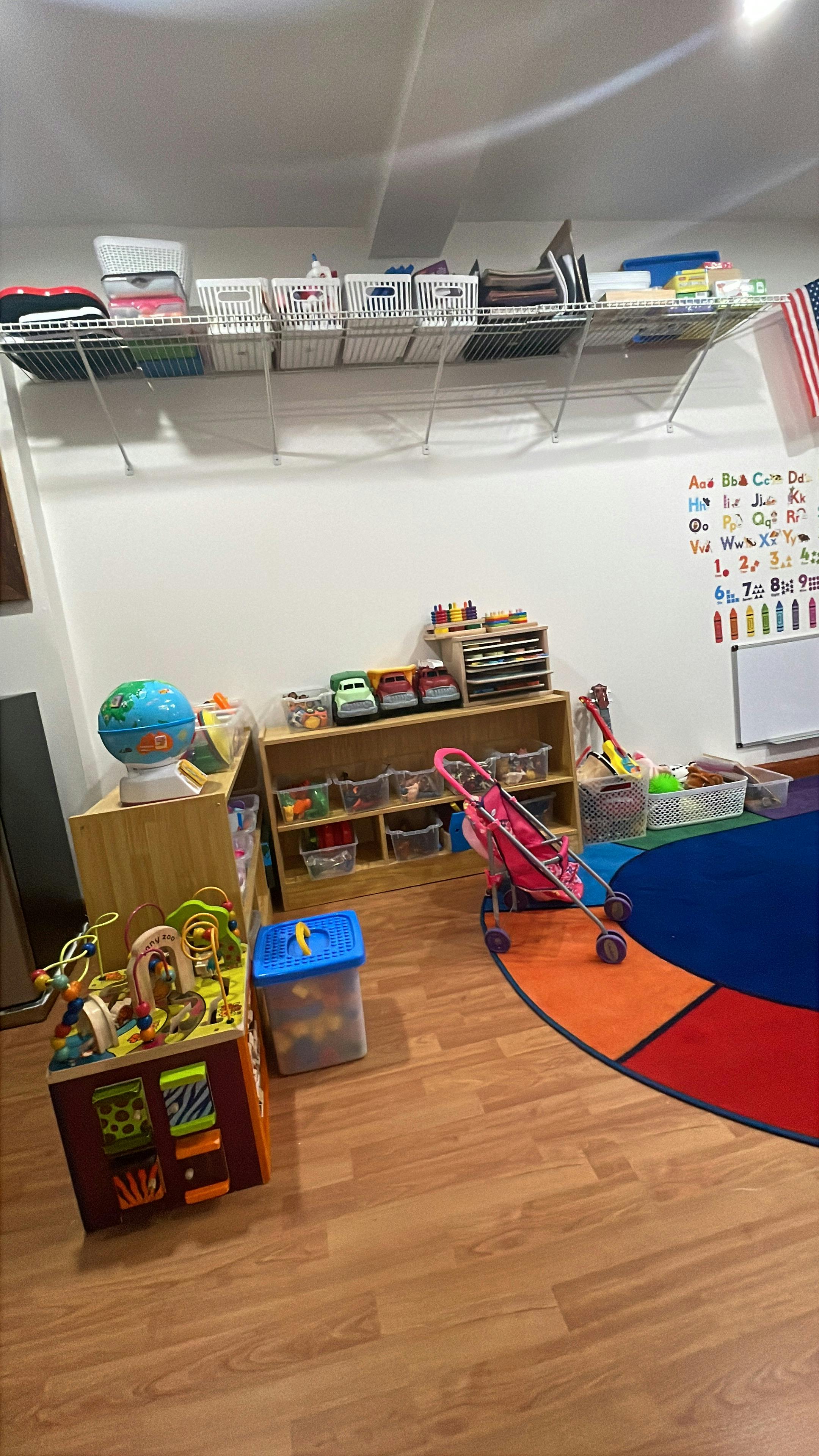 Playroom with toys, shelves, and a colorful rug