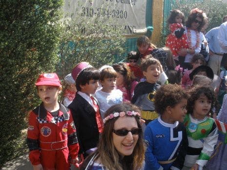 Group of children and adults in costumes outdoors setting with some children in costumes