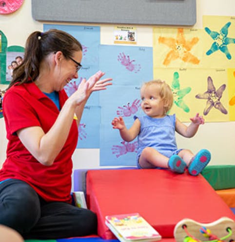 Person playing with a child in a classroom
