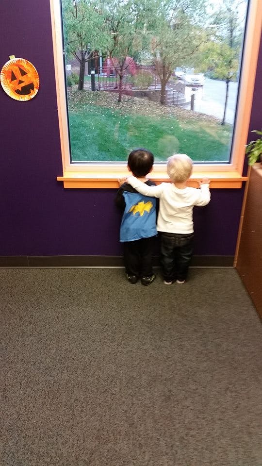 Two children looking out a window
