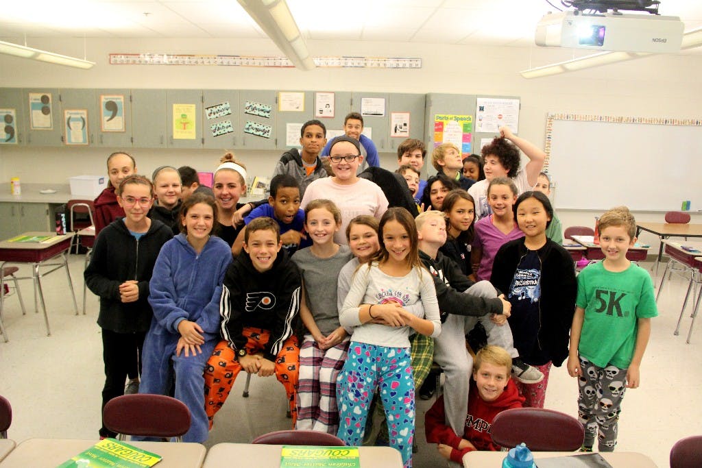 Group of children and adults posing in a classroom