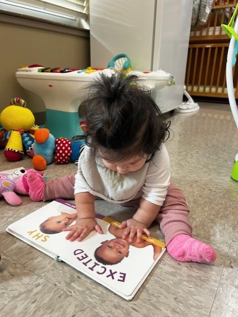 Child sitting on floor with an open book