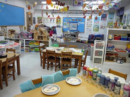 Classroom with tables, chairs, and art supplies
