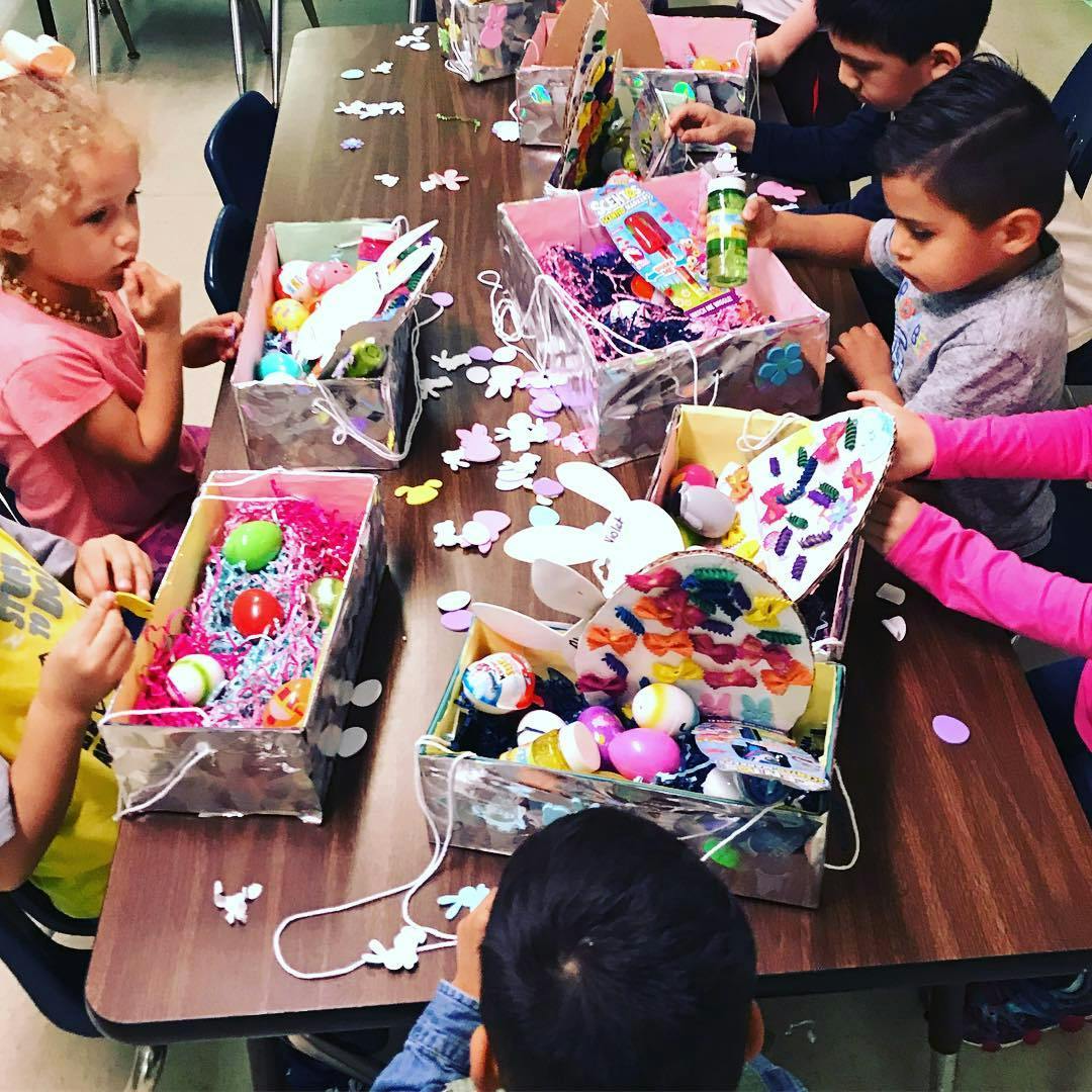 Children decorating Easter baskets at a table