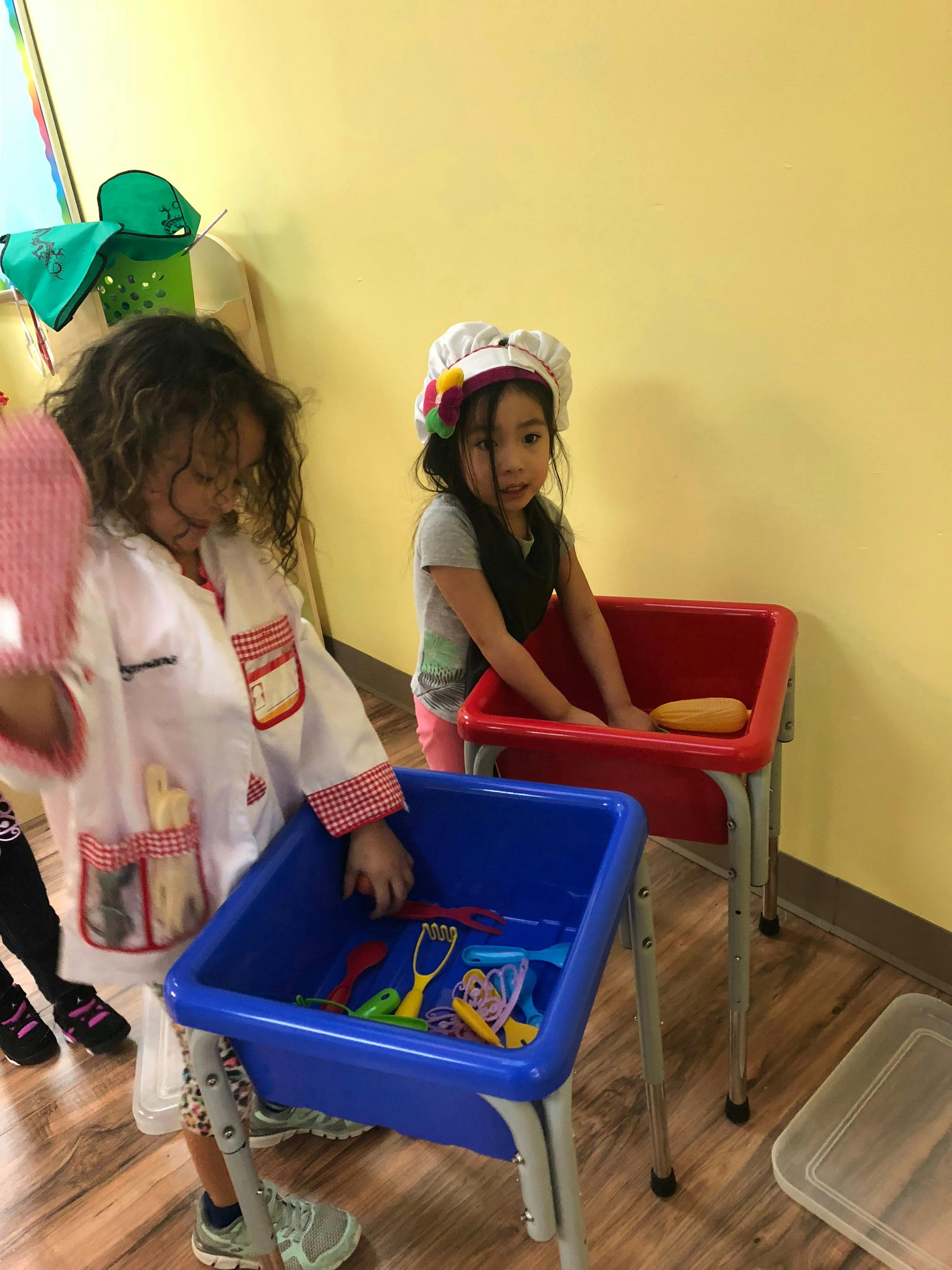 Two children playing with toys in bins
