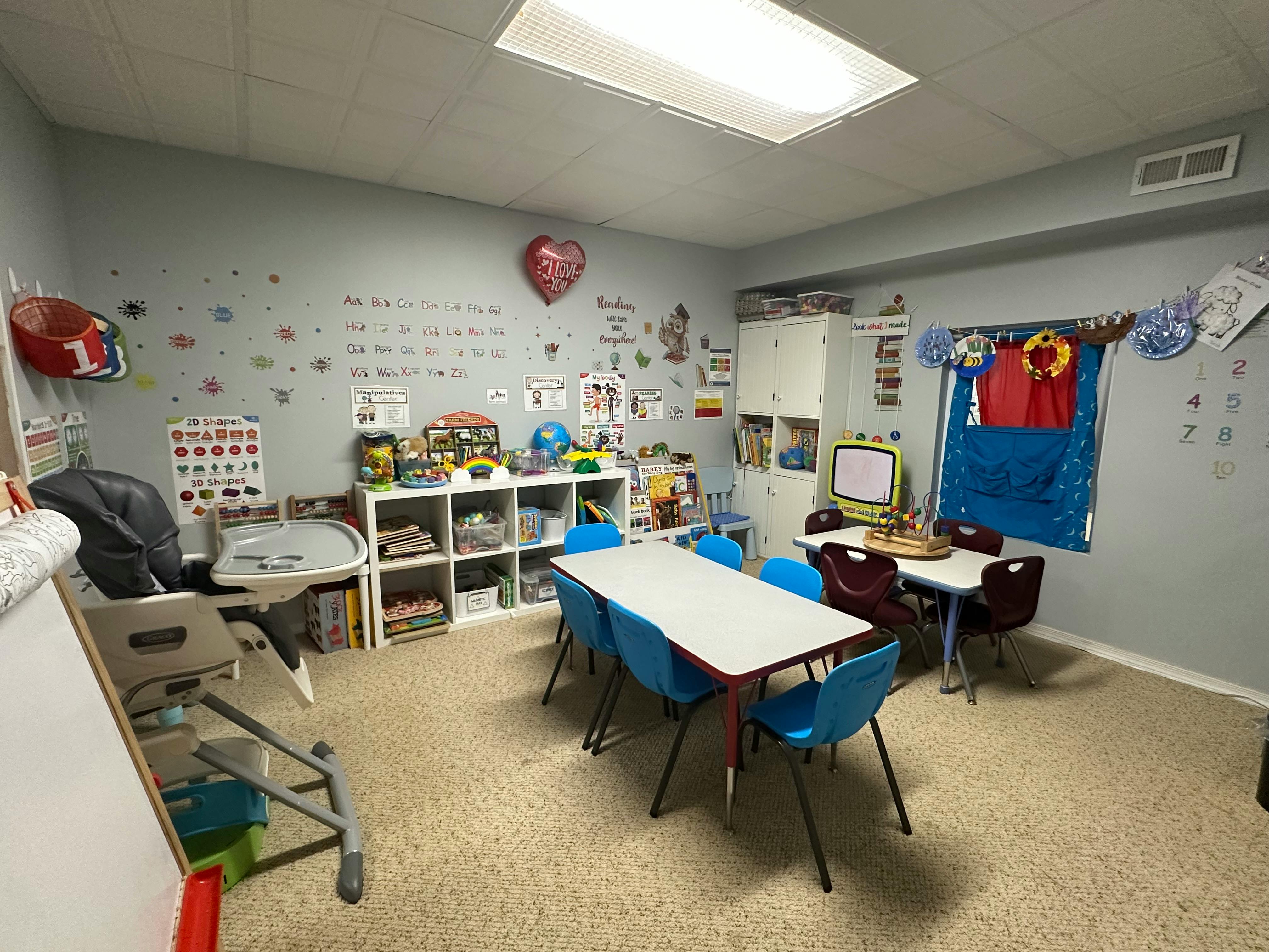 Classroom with tables, chairs, and shelves