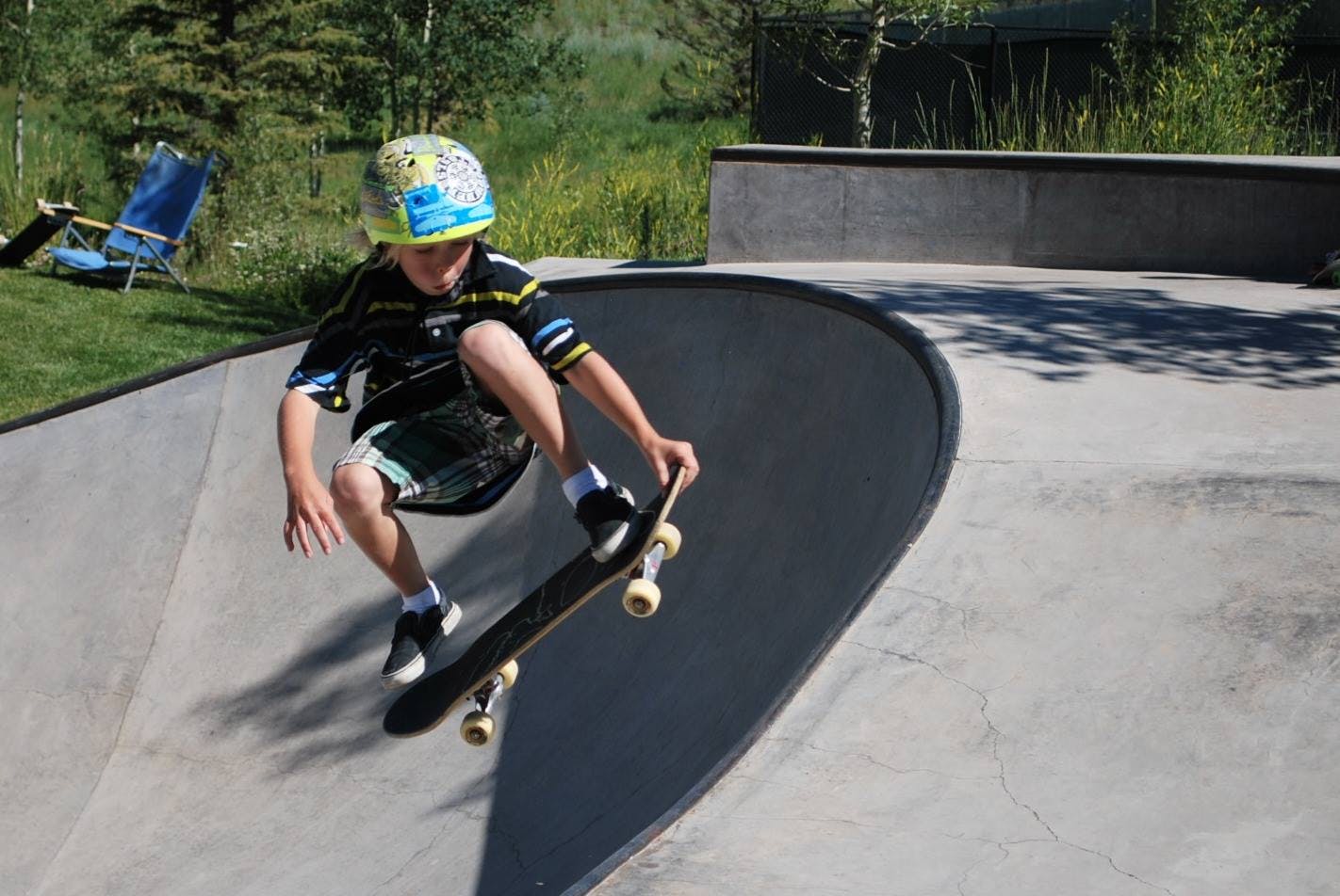 Child in a helmet skateboarding in a skate park