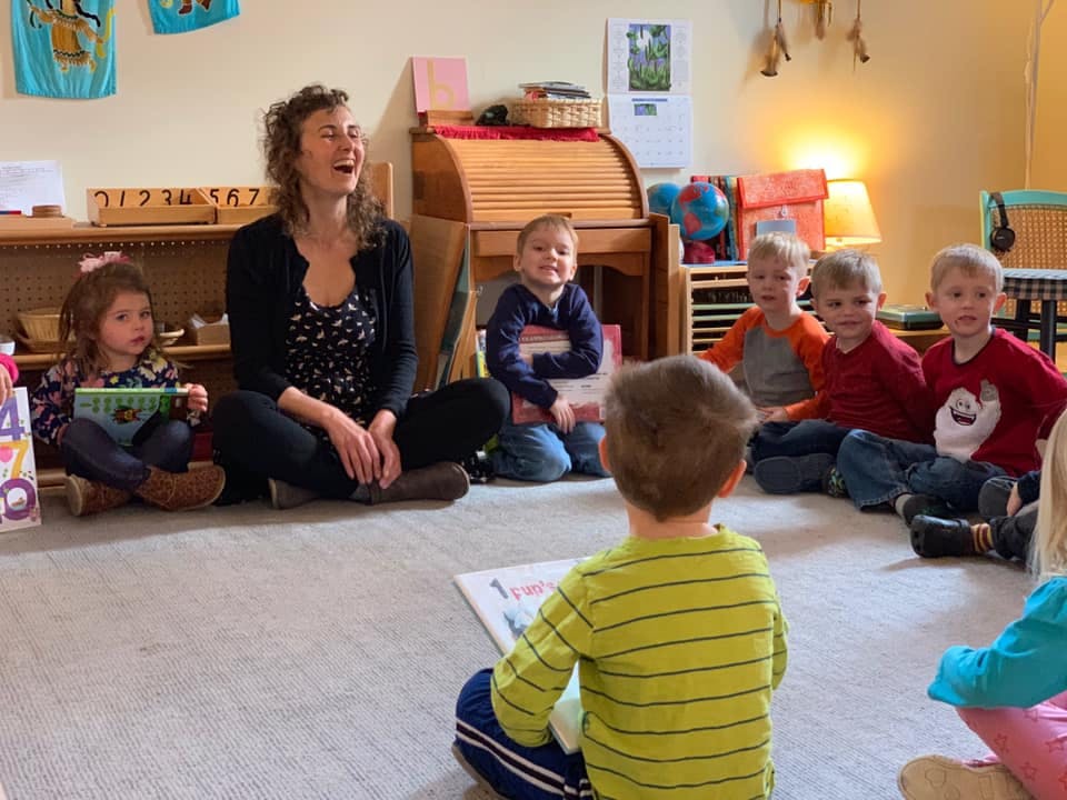Adult and children sitting on floor in a circle