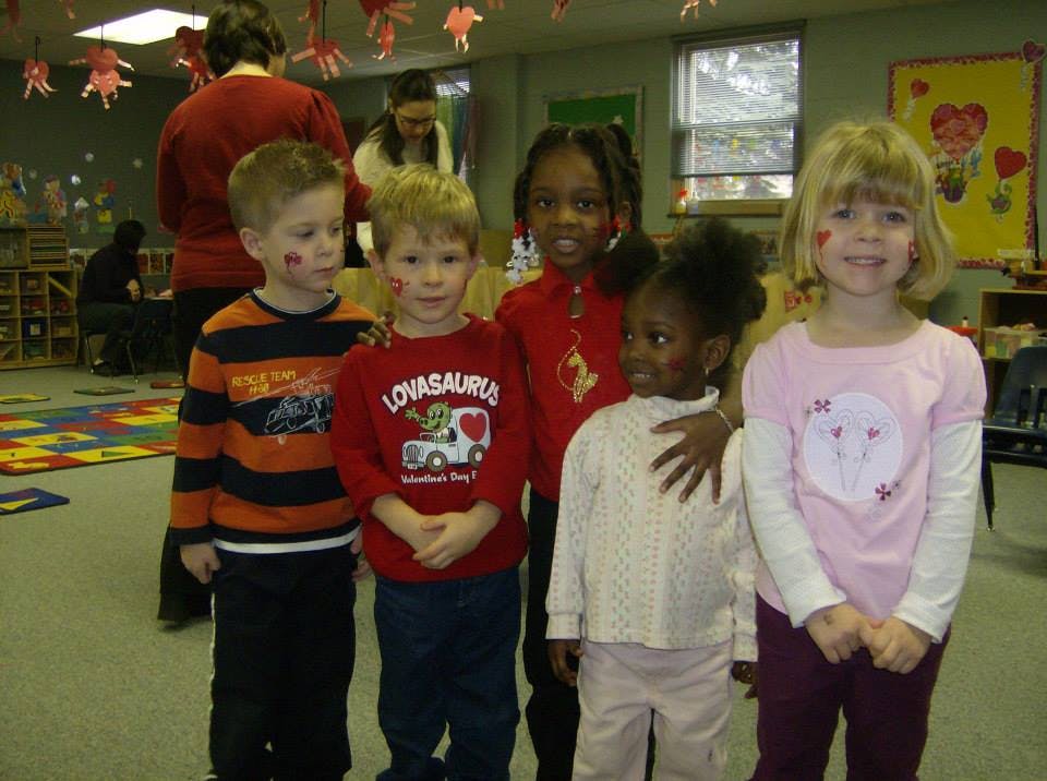 Five children standing together in a room