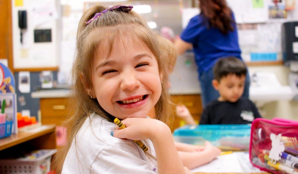 Child smiling in a classroom