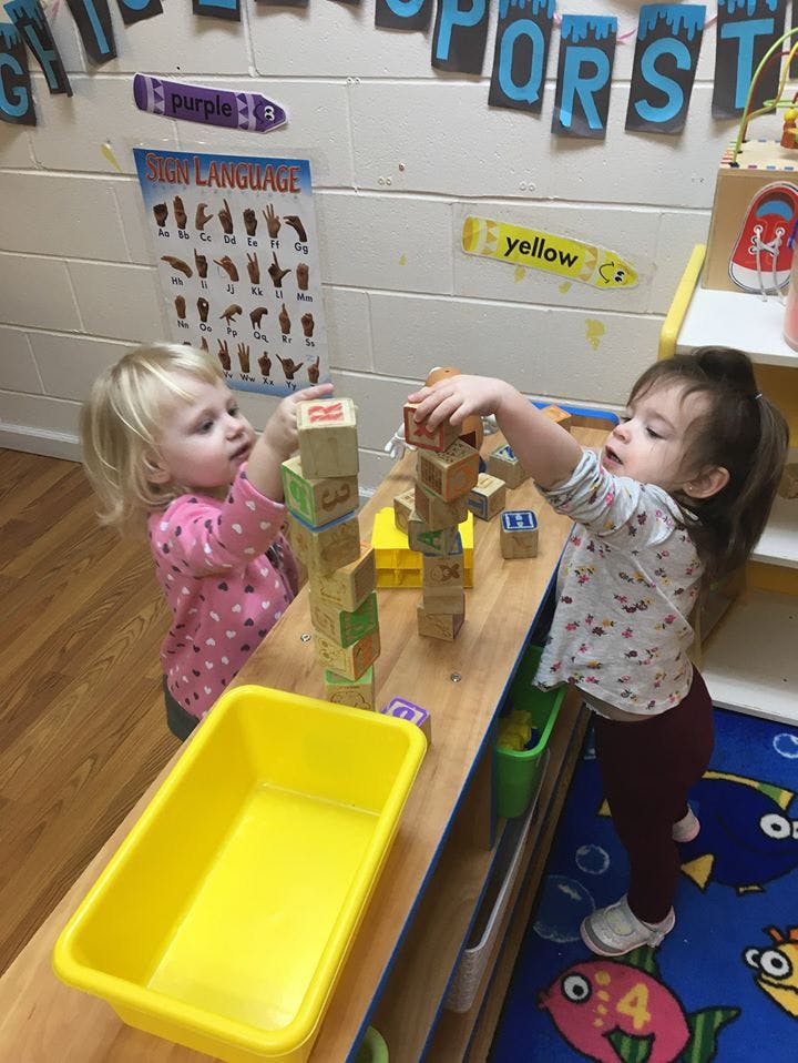 Two children playing with wooden blocks