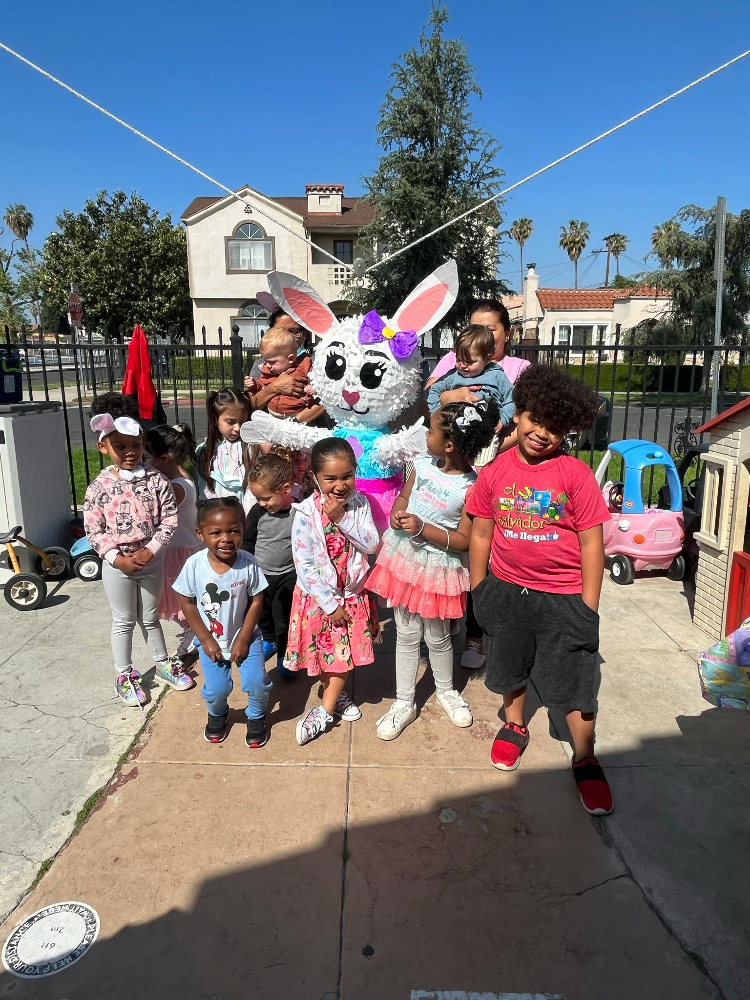 Children and adults posing with a large bunny mascot