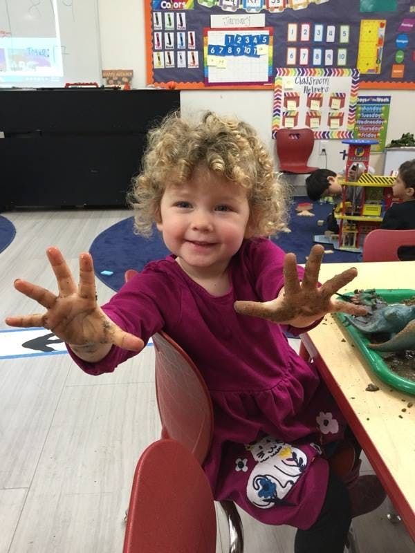 Child with dirty hands in a classroom