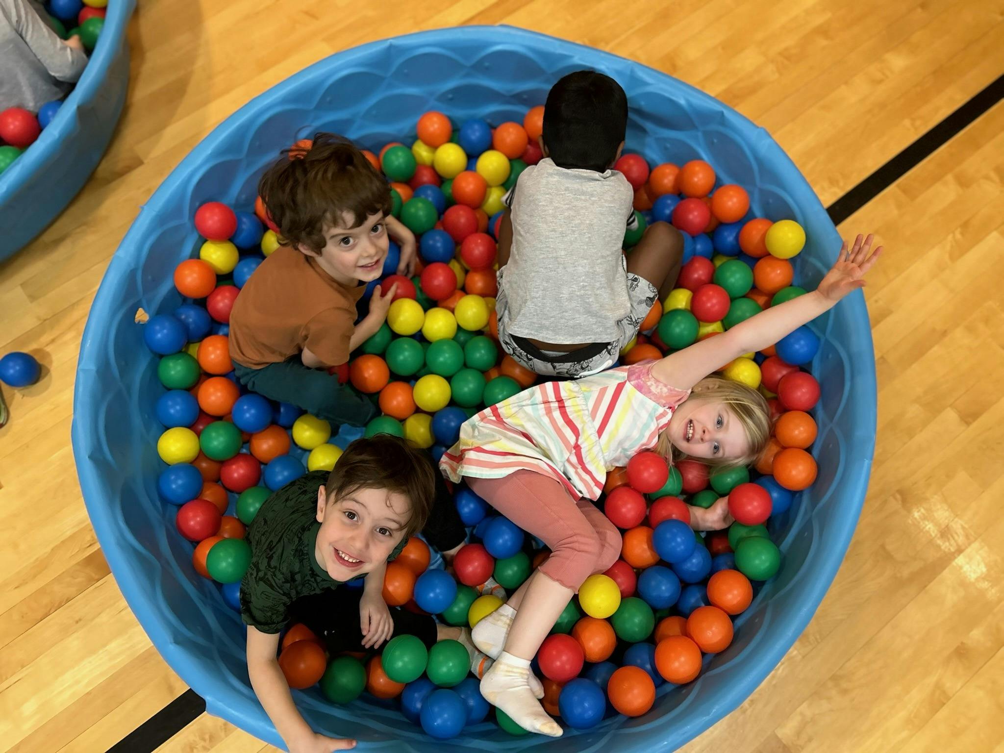 Four children playing in a ball pit
