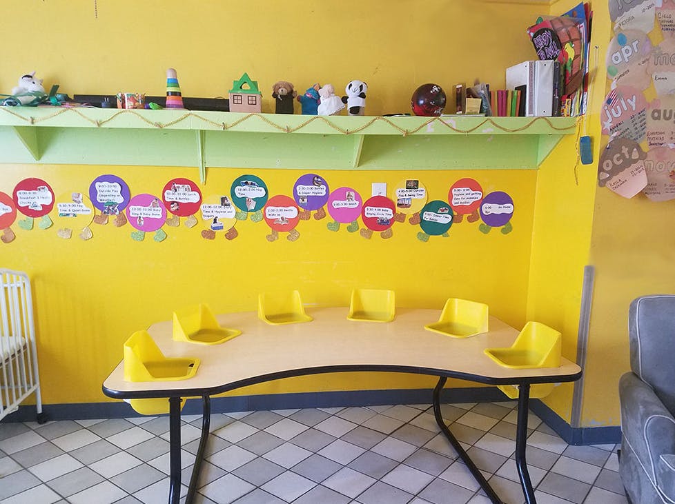 Classroom with a curved table and yellow chairs, colorful wall decorations