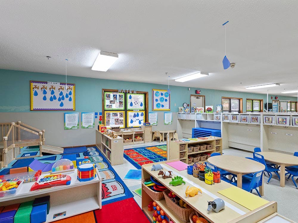 Colorful classroom filled with toys, small tables, and learning decorations
