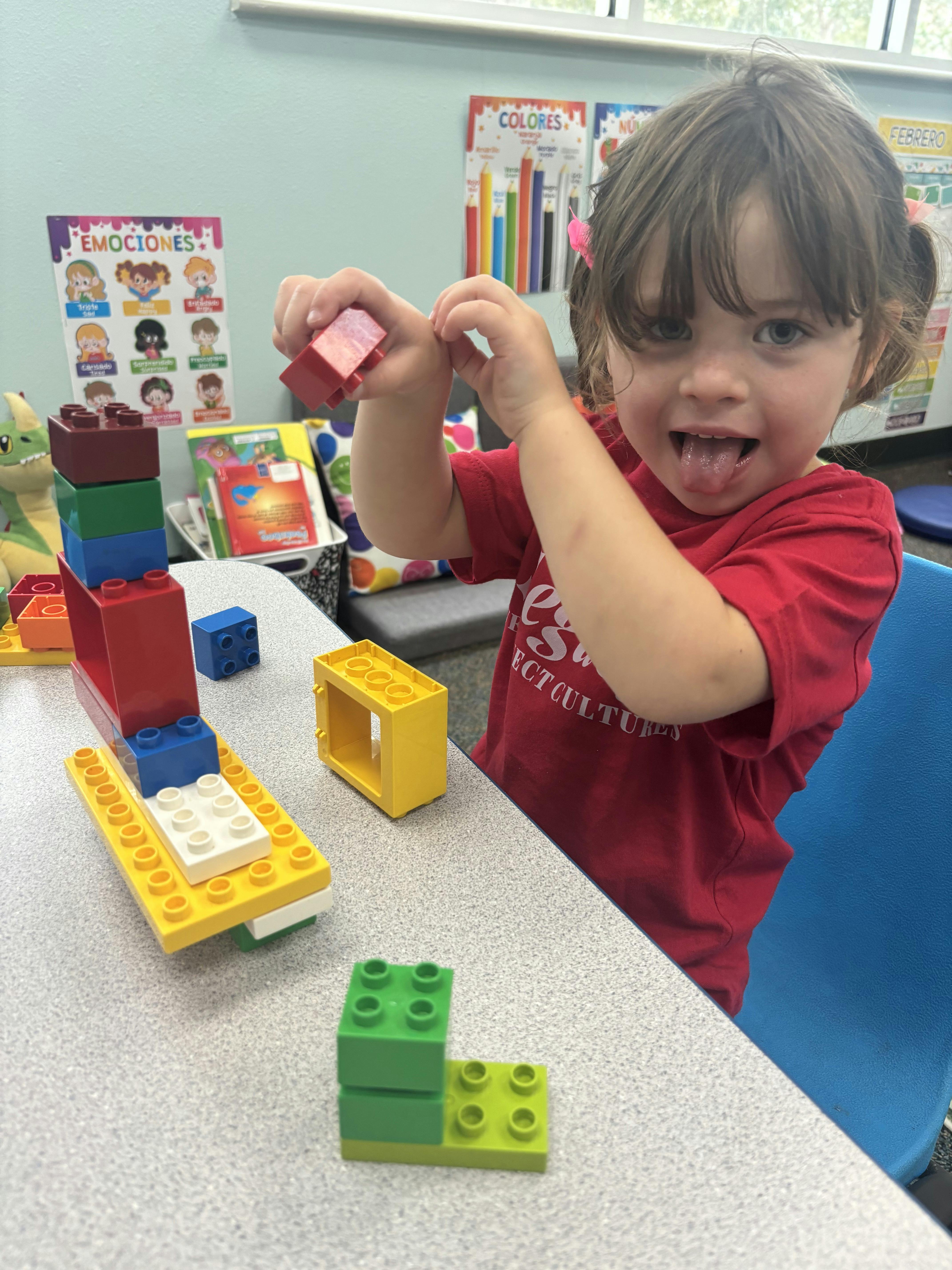 Child playing with colorful building blocks on a table