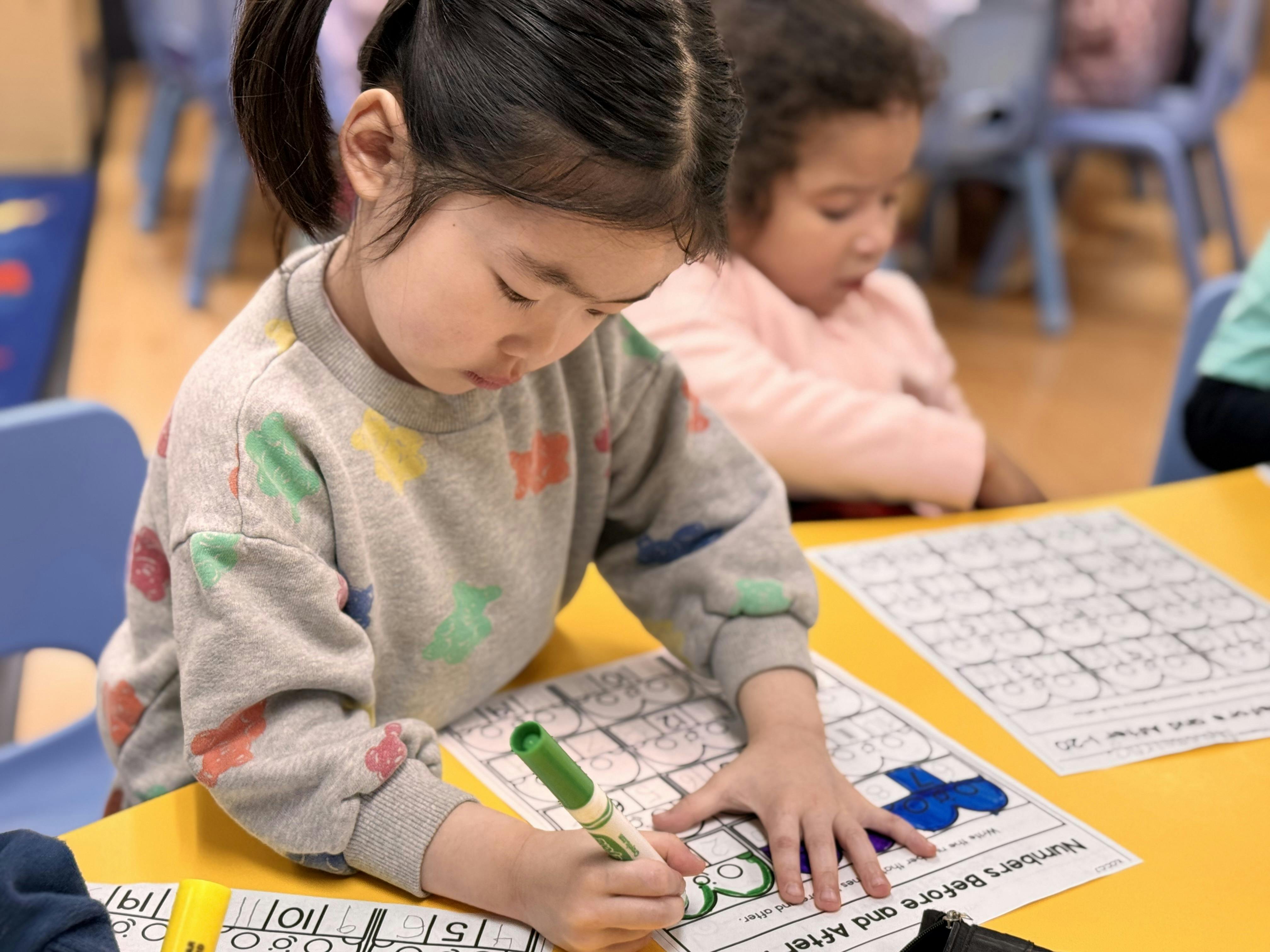 Child coloring a worksheet at a table
