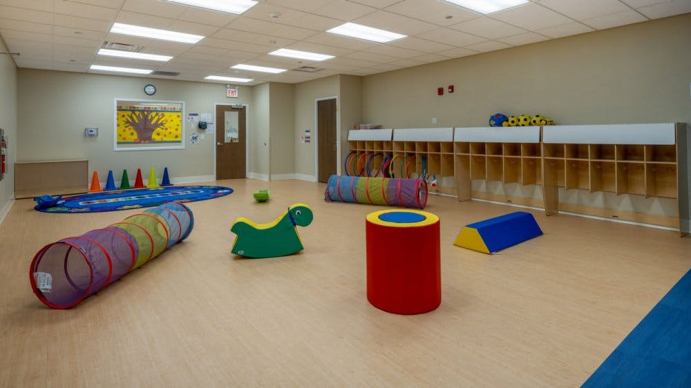 Playroom with colorful tunnels, soft play shapes, and cubbies