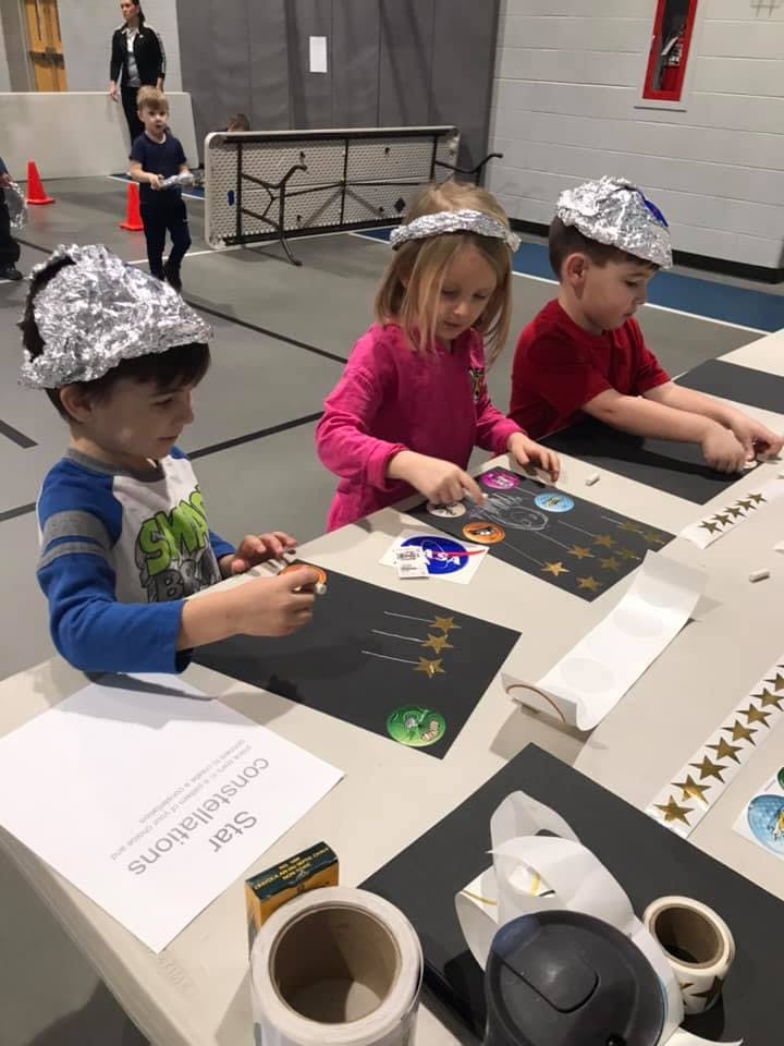 Three children making crafts at a table