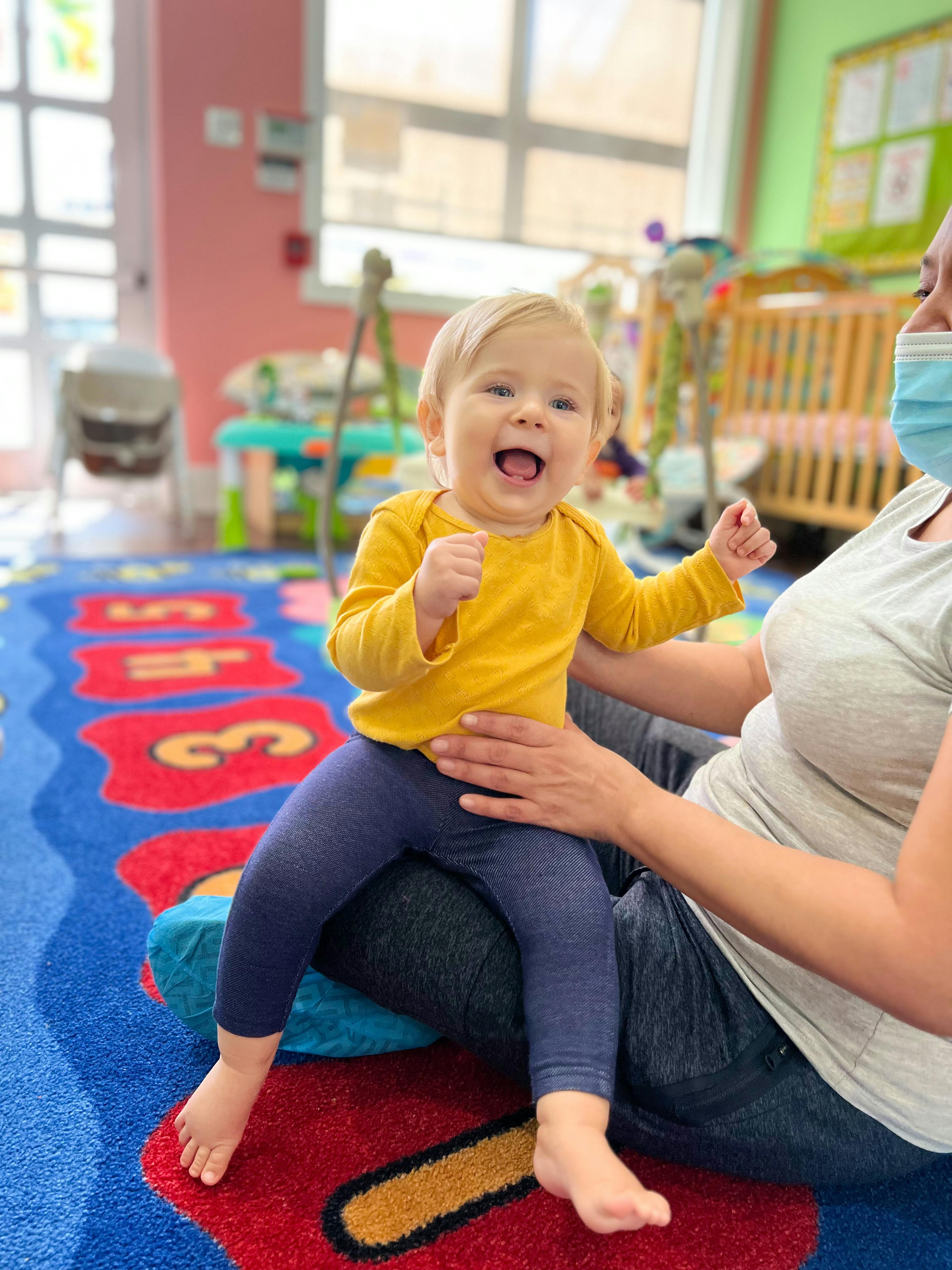 Child sitting on a person's lap in a classroom