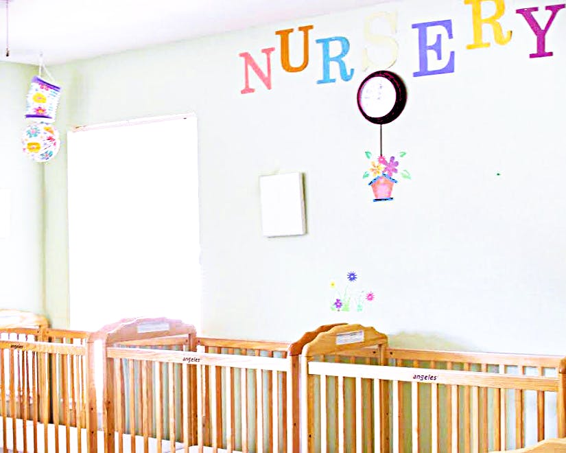 Cribs in a room with the word NURSERY on the wall