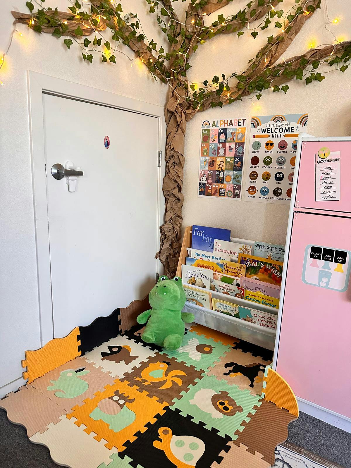 Play area with animal floor mats, a bookshelf, and a plush toy