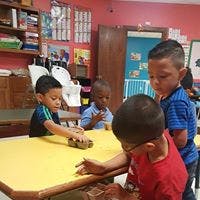 Four children at a table in a classroom
