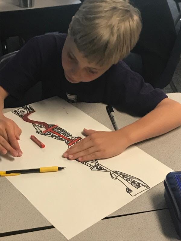 Child coloring a drawing on paper