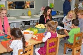 Adults and children preparing food in a kitchen
