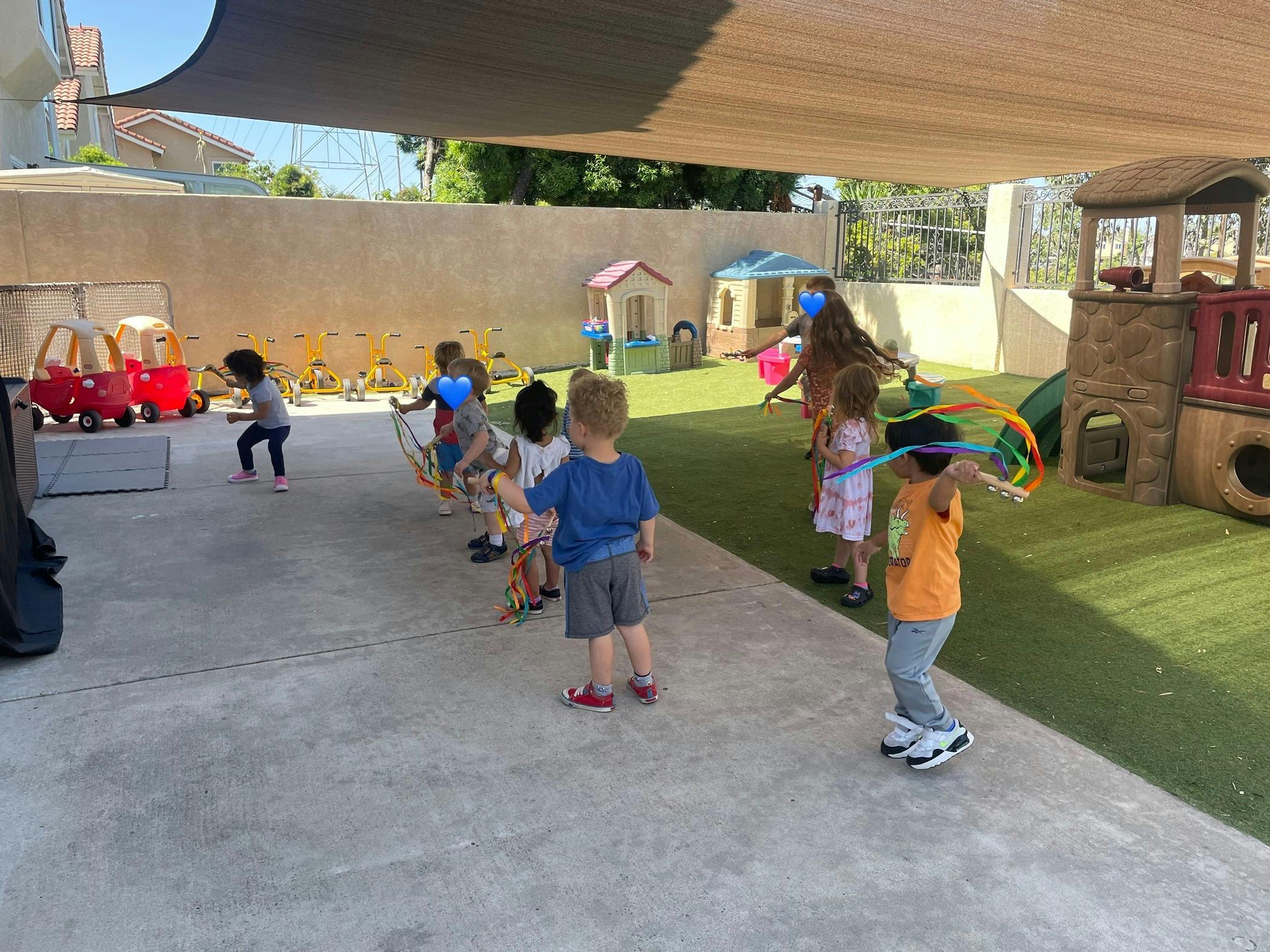 Children playing outdoors on a playground with artificial grass