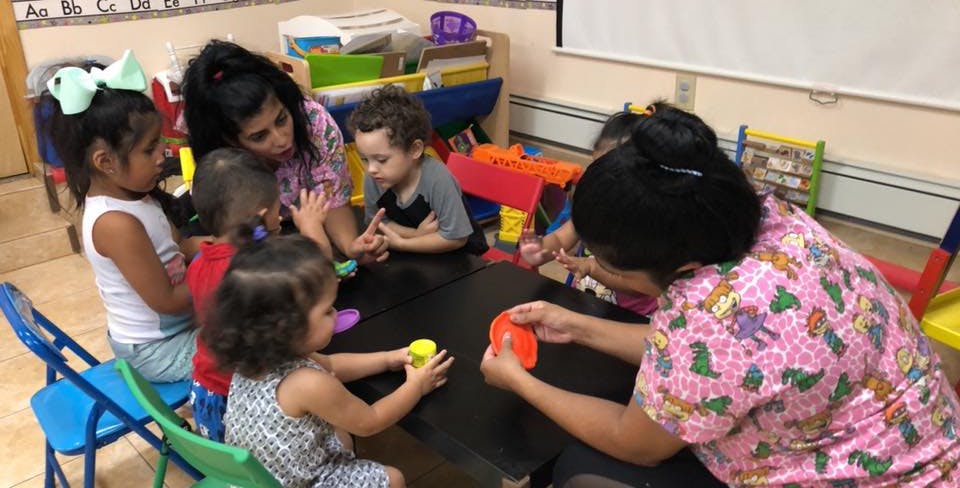 Adults and children playing with toys at a table