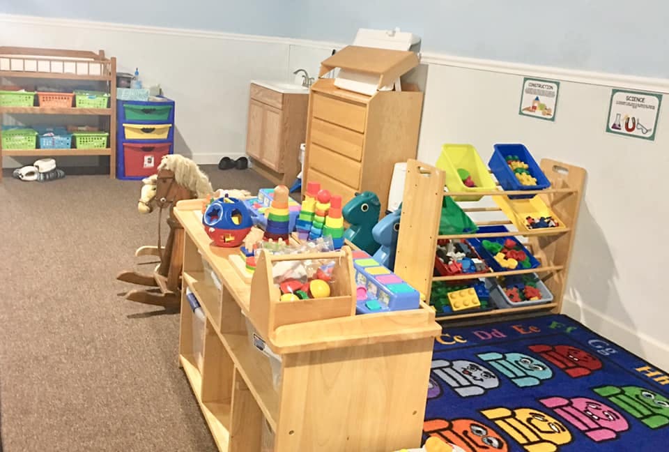 Playroom with toys, storage shelves, and a rocking horse