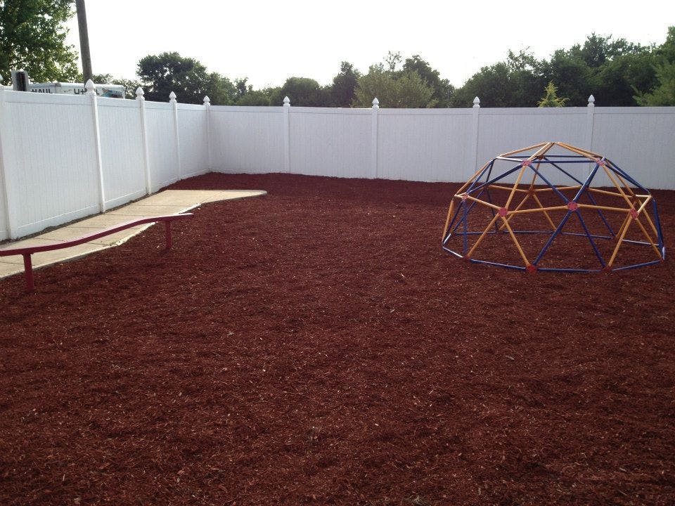 Playground with a climbing dome and a white fence