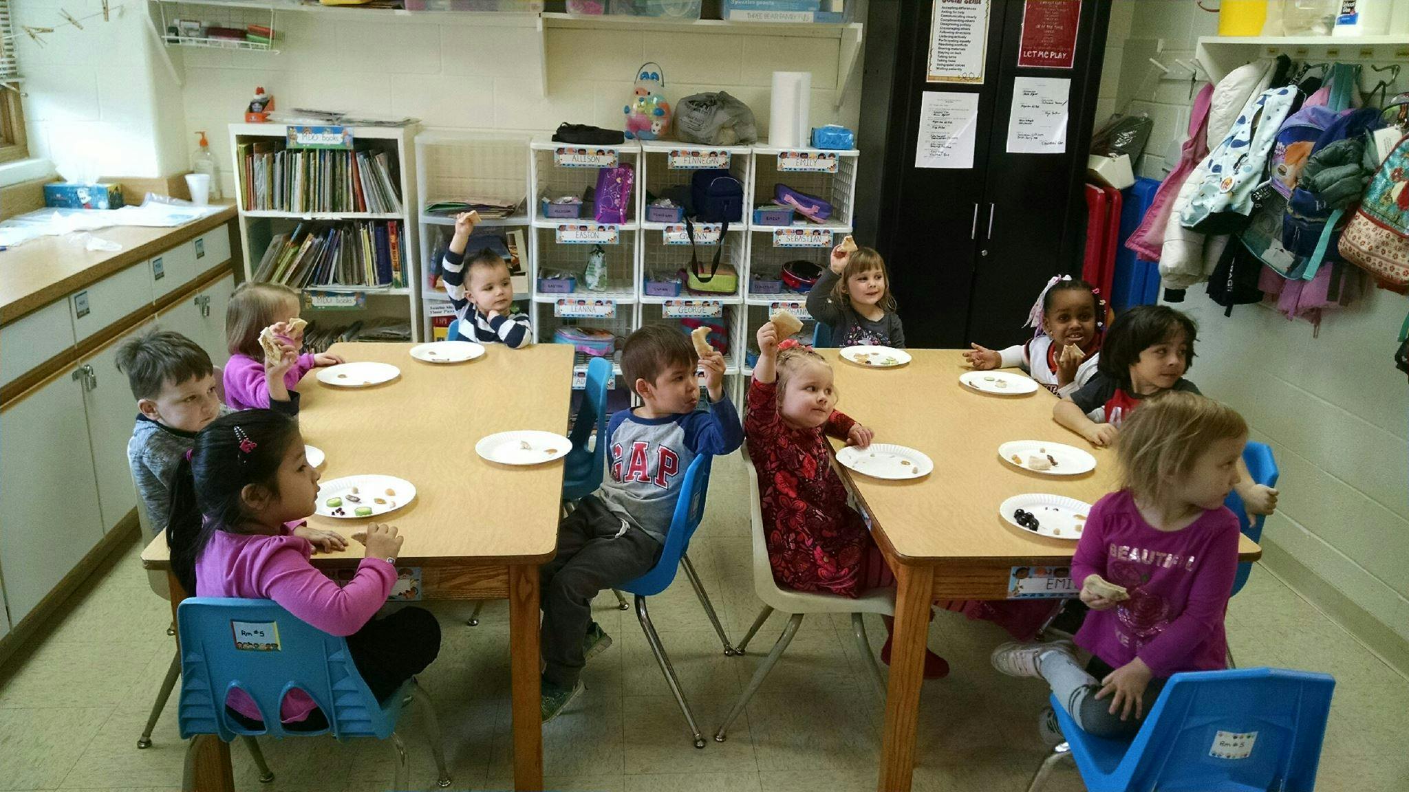 Children sitting at tables in a classroom